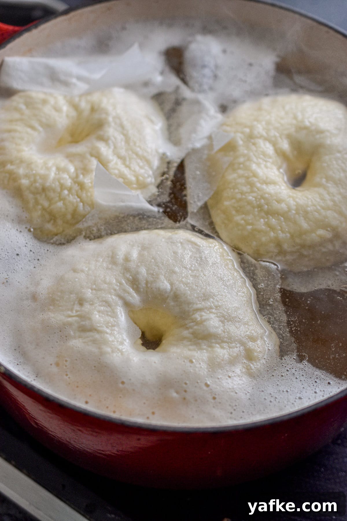 New York-Style Bagels Made with Sourdough Discard 9 Three bagels are being boiled.