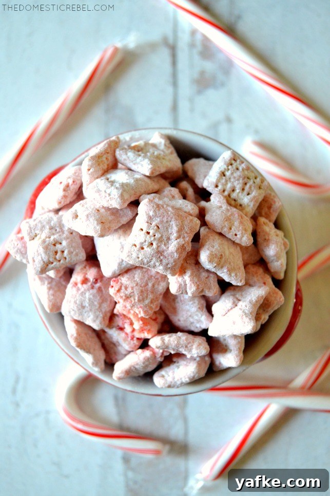 Bowl of peppermint candy cane muddy buddies surrounded by candy canes
