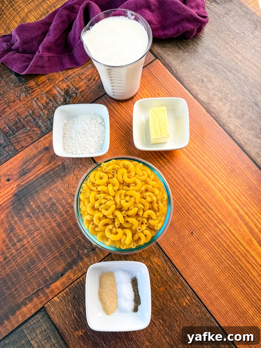 Southern Soul Food Baked Mac and Cheese Recipe 2 Overhead photo of mac and cheese ingredients on a wooden surface, including elbow macaroni, flour, butter, milk, and small bowls of garlic powder, salt, and pepper.