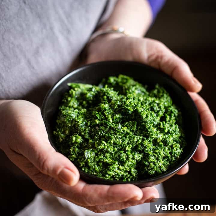Wild Garlic Pesto Recipe for Spring 4 woman's hands holding a small black bowl of wild garlic pesto