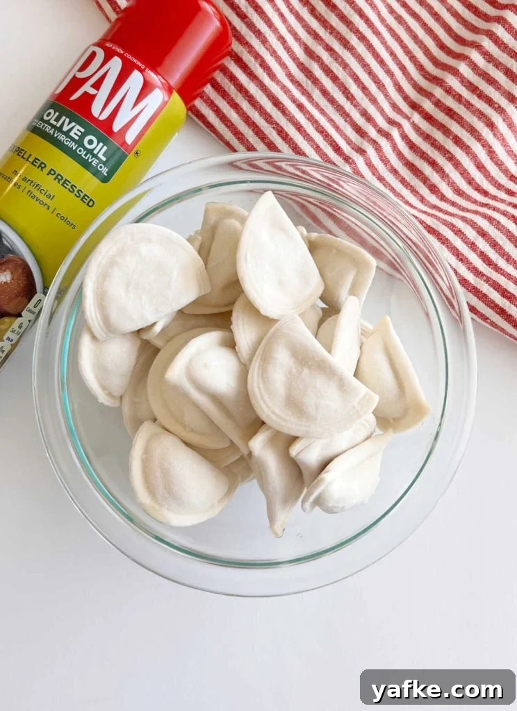 Crispy Air Fryer Pierogies in 15 Minutes 3 olive oil spray and Mrs T's frozen pierogies in a bowl