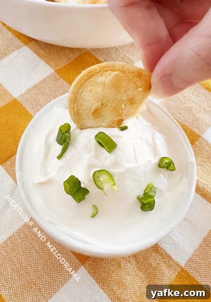 Crispy Air Fryer Pierogies in 15 Minutes 6 hand dipping air fried pierogi in sour cream