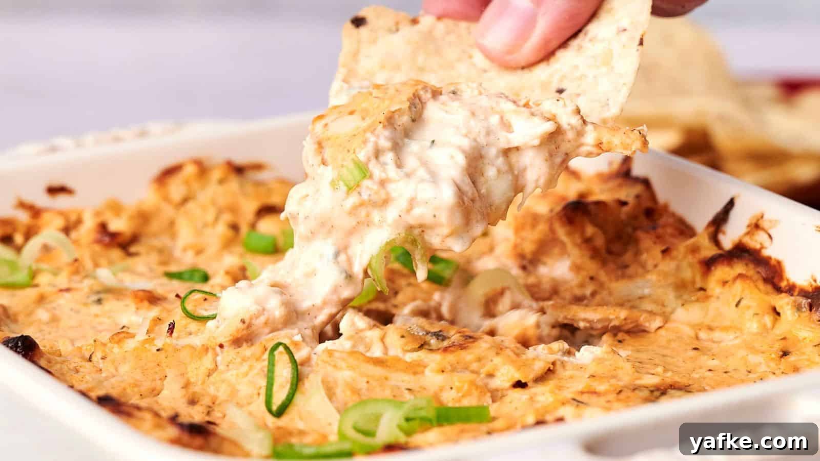 21 Fall Snacks I Tried: 9 Keepers 18 A hand dips a tortilla chip into a cheesy baked dish topped with sliced green onions.