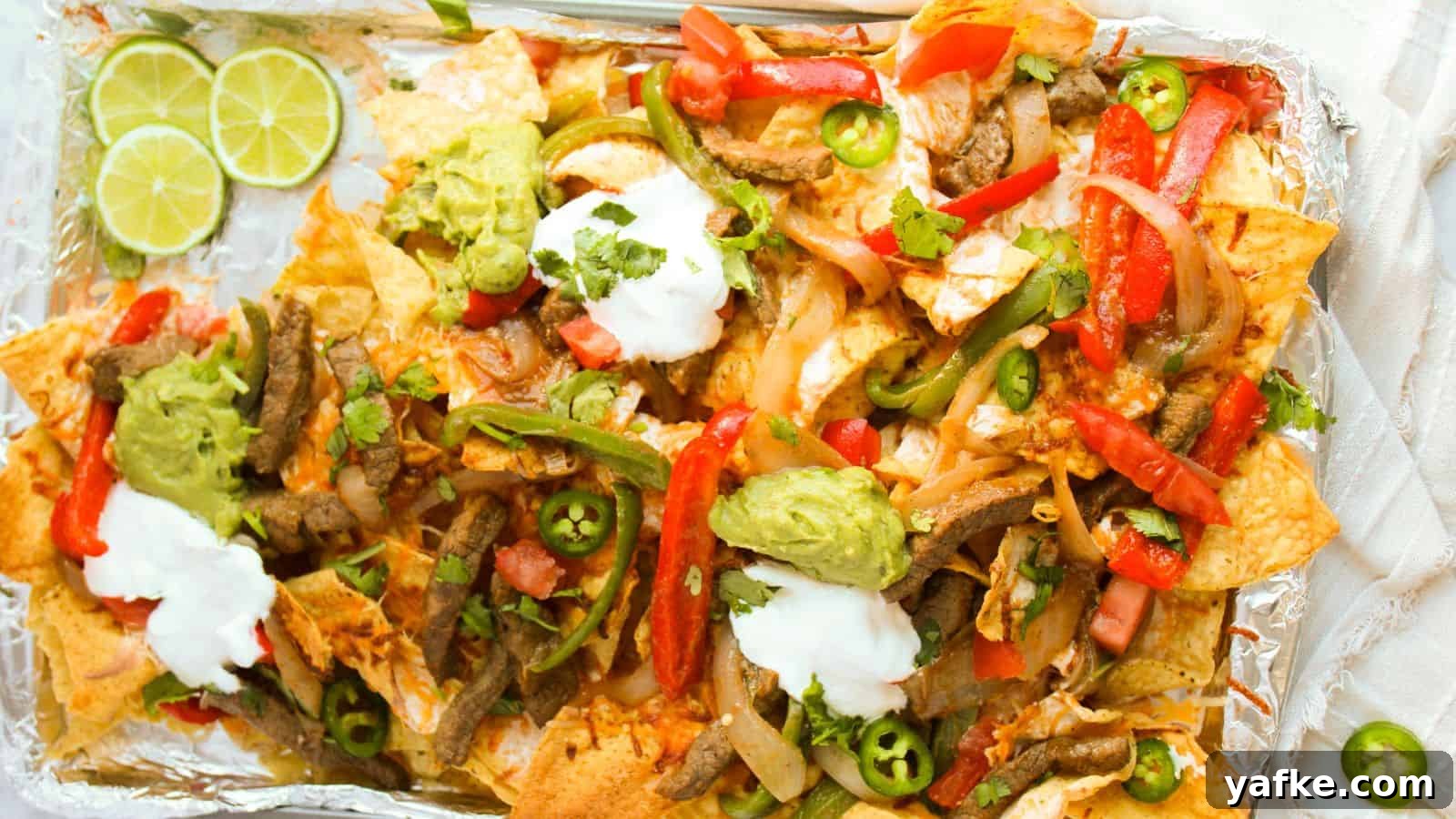 21 Fall Snacks I Tried: 9 Keepers 21 A tray of loaded nachos topped with sliced beef, red and green peppers, jalapeños, guacamole, sour cream, and lime wedges on the side.