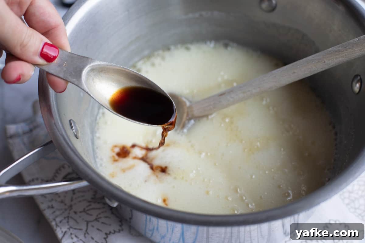 Homemade Buttermilk Syrup for Pancakes and Waffles 10 Adding vanilla to a pot of bubbly syrup.
