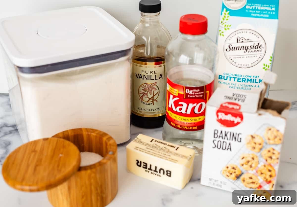 Homemade Buttermilk Syrup for Pancakes and Waffles 5 Sugar, vanilla, karo syrup, buttermilk, baking soda, butter, and salt on a white countertop.