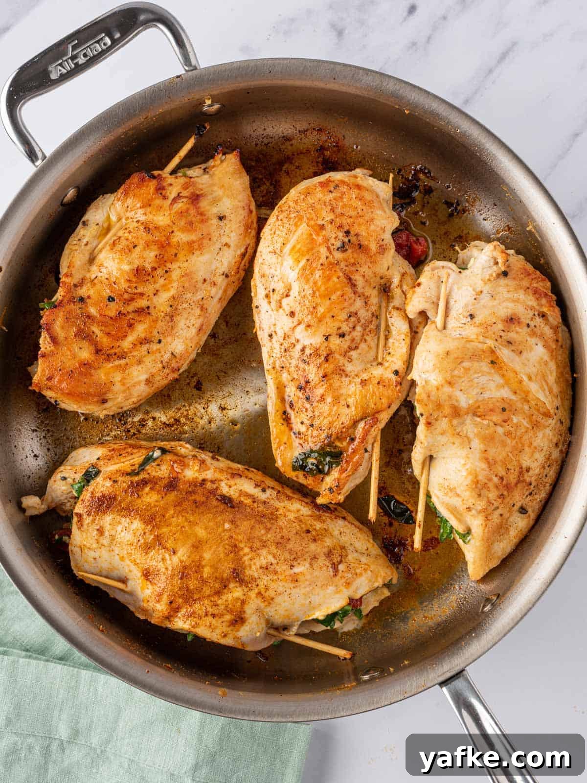 Mediterranean Stuffed Chicken Breast with Spinach and Feta 6 Mediterranean stuffed chicken breasts seared in a pan.