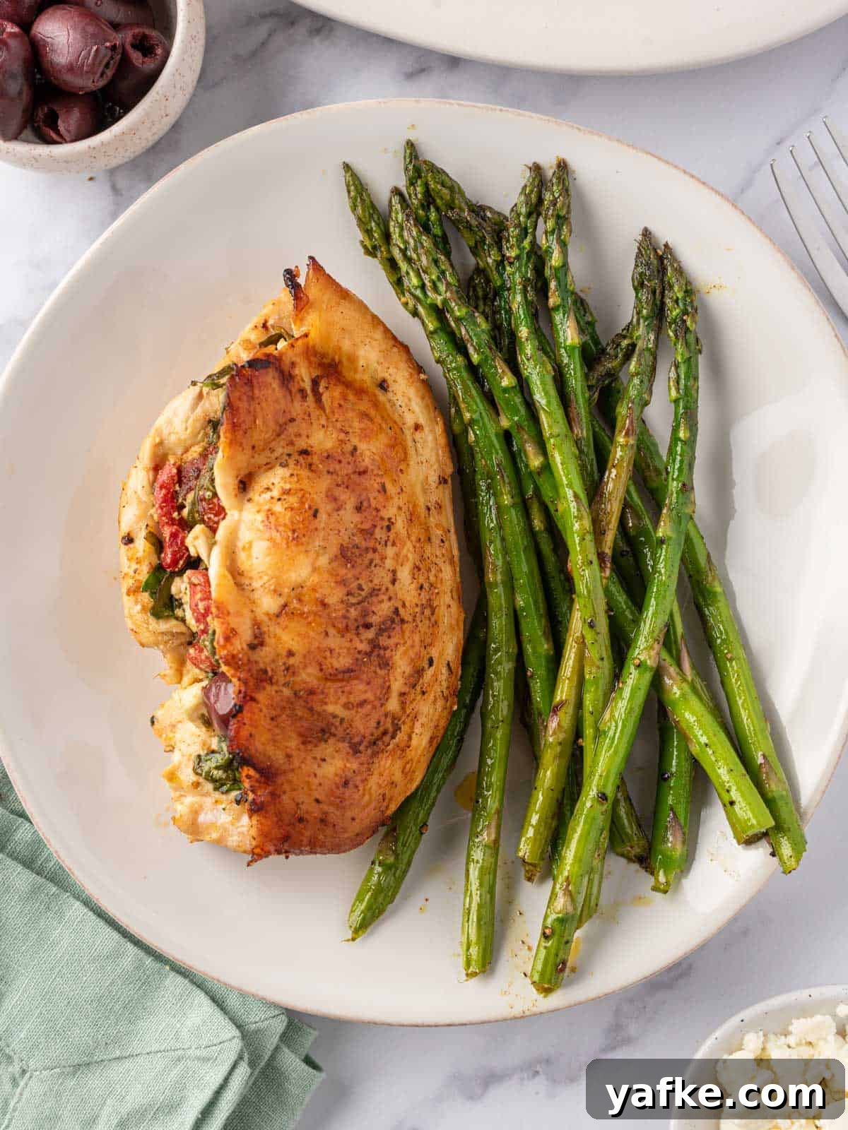 Mediterranean Stuffed Chicken Breast with Spinach and Feta 8 A plate of asparagus with Mediterranean stuffed chicken breast.