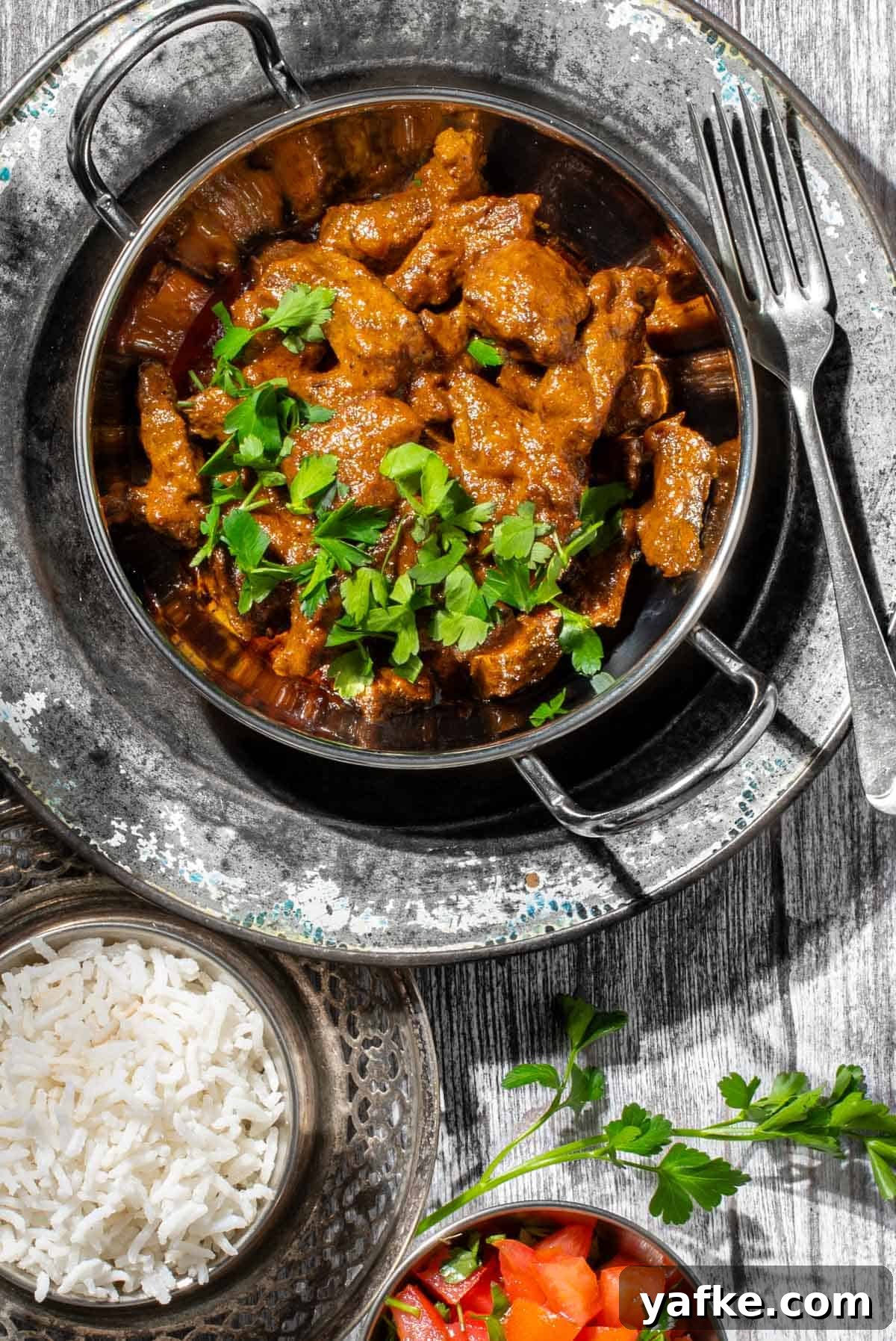 Creamy Beef Curry with Coconut Milk Recipe 2 Aromatic beef curry with coconut milk in a balti bowl with a side of rice.