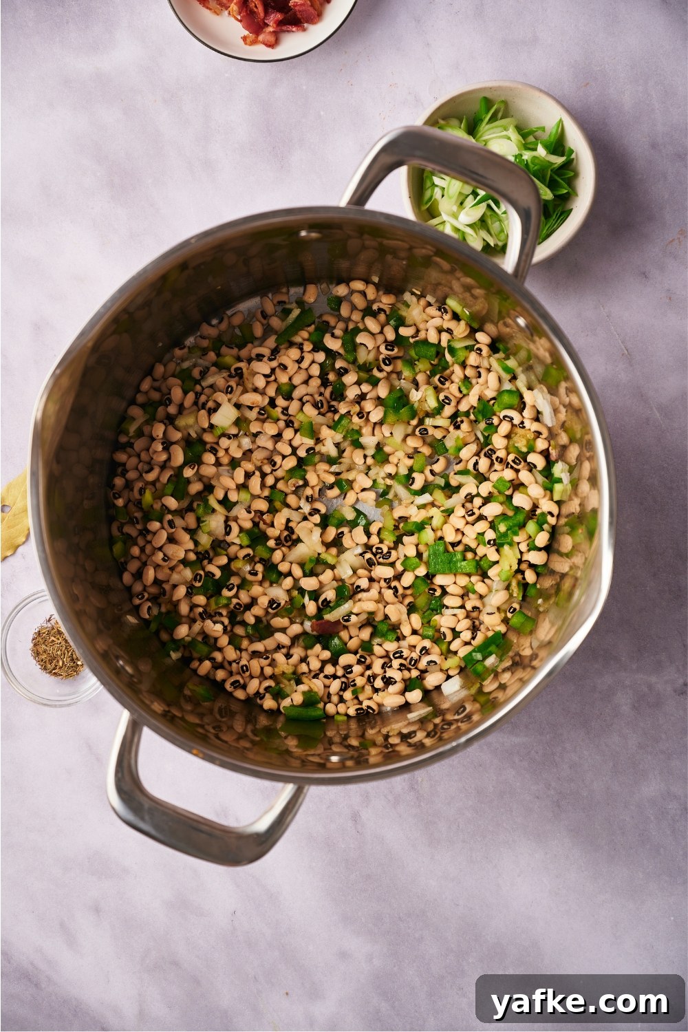 Large pot with diced vegetables and black eyed peas.