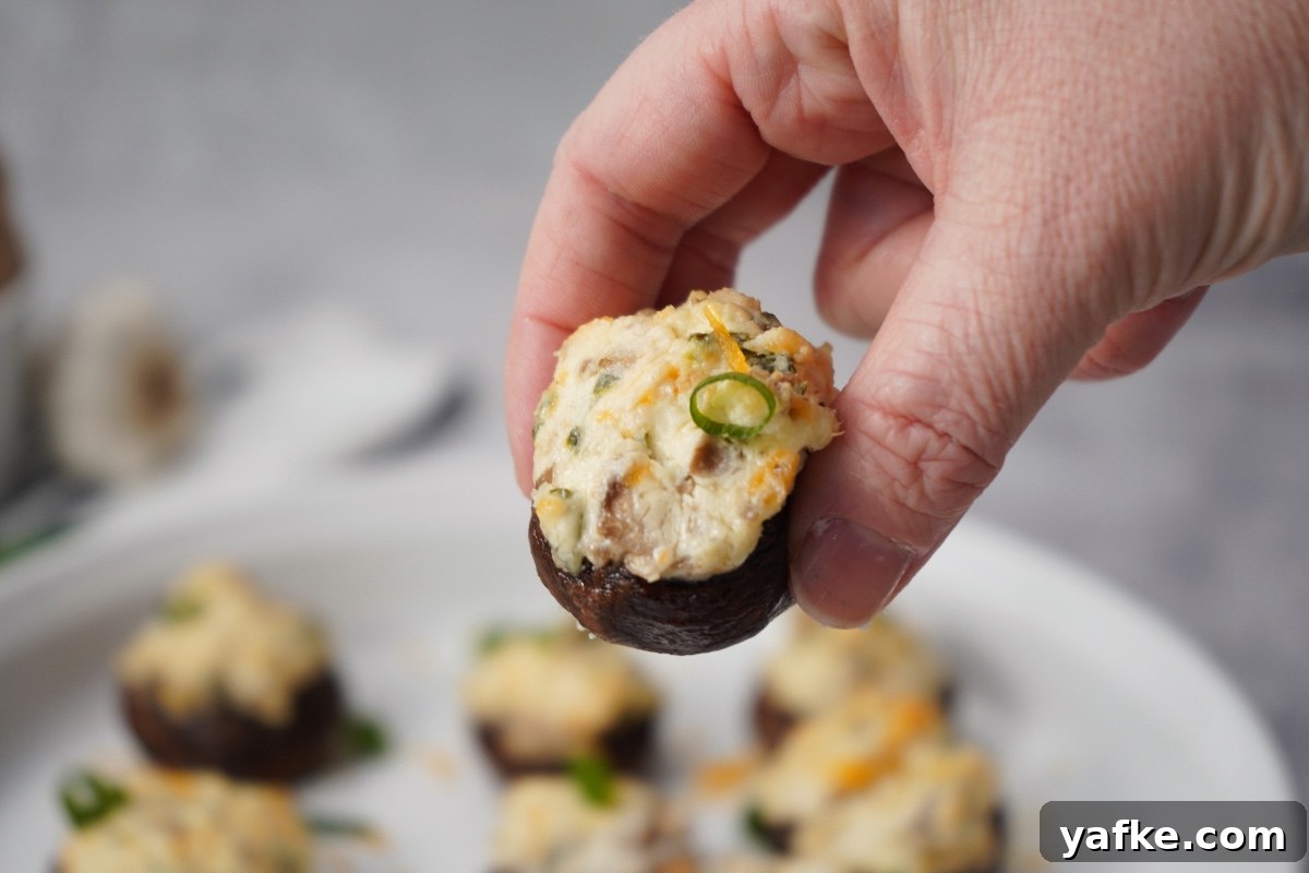Smoked Stuffed Mushrooms Recipe with Bacon and Parmesan 4 hand holding smoked stuffed mushrooms