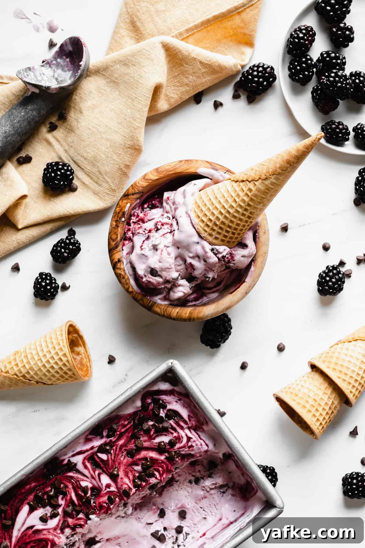 Creamy No-Churn Blackberry Chocolate Chip Ice Cream Recipe 3 Overhead shot of a bowl of blackberry chip ice cream with a cone sitting inside.
