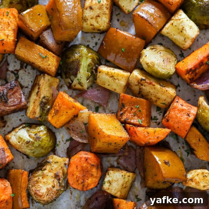 A close up overhead image of roasted autumn vegetables on a pan.