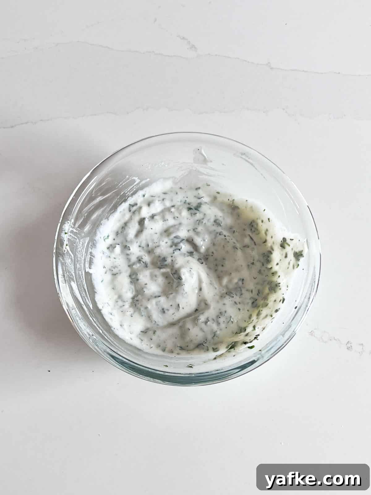 Roasted Delicata Squash with Herbed Yogurt Recipe 5 A glass bowl of herbed yogurt.