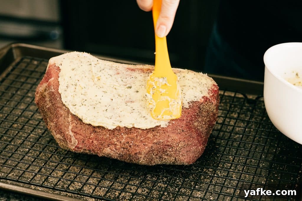 Smoked Bottom Round Roast with Garlic and Herbs Recipe 3 Garlic herb butter being spread on a whole bottom round roast.