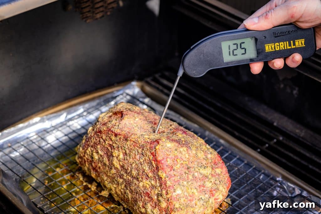 Smoked Bottom Round Roast with Garlic and Herbs Recipe 5 Instant-read thermometer showing 125 degrees F in a smoked bottom round roast.