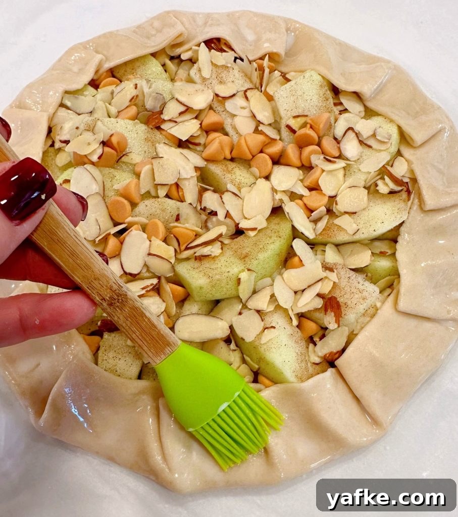 Rustic Apple Almond Galette Recipe with Flaky Crust 11 Brushing the edge of the crust with milk.