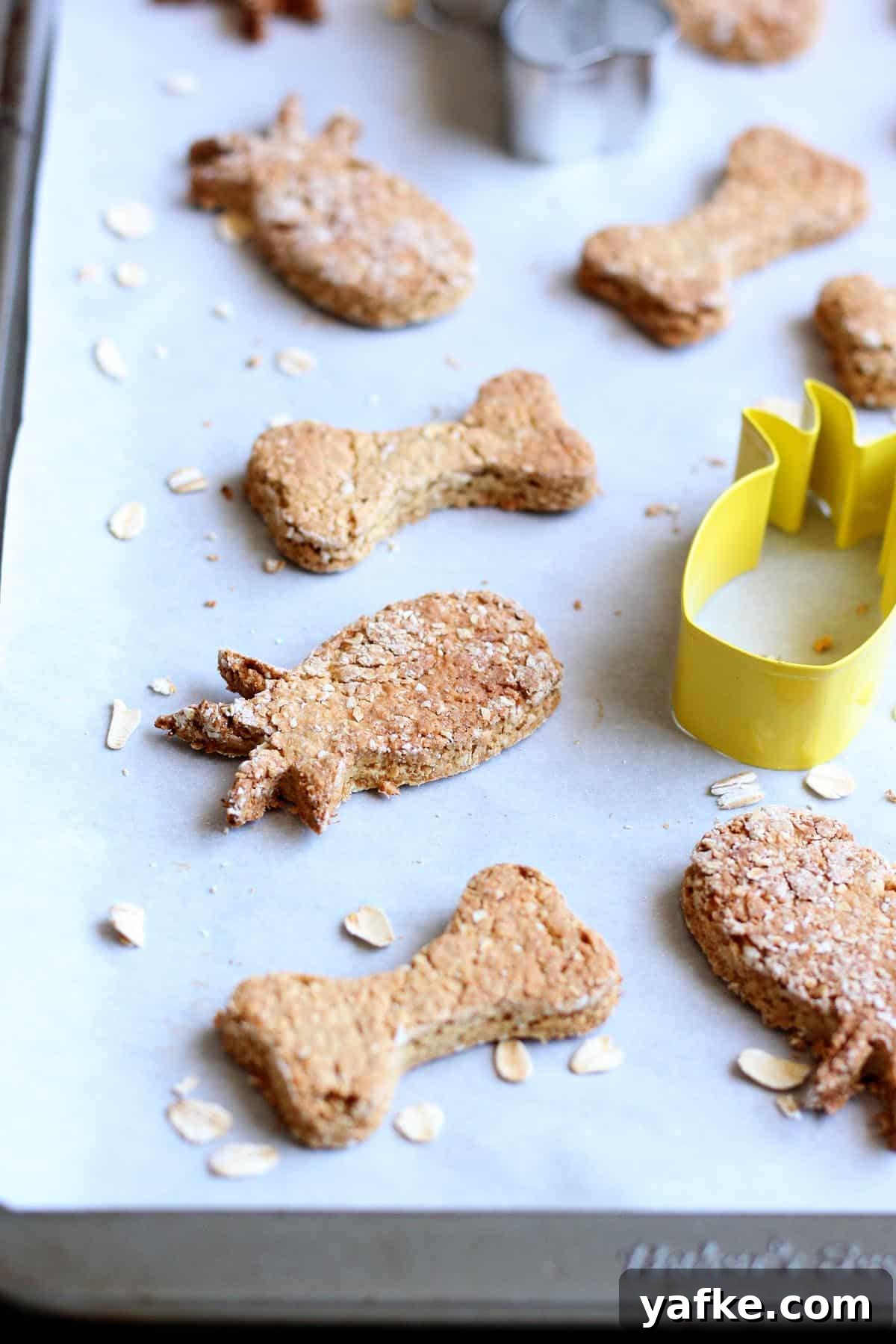 Homemade Pineapple Dog Treats Your Pup Will Love 2 Pineapple dog treats on a lined baking sheet.