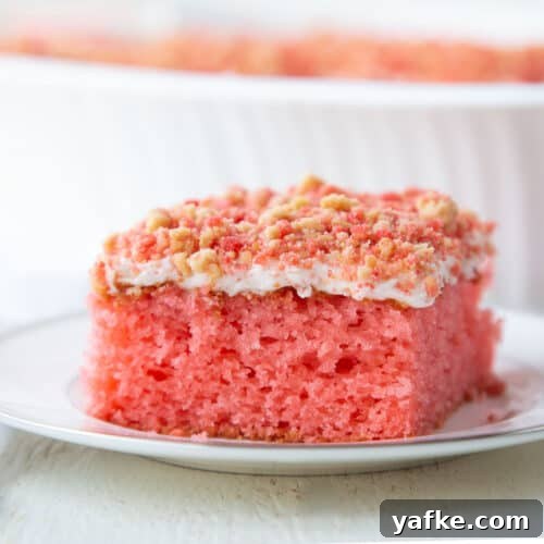 slice of strawberry crunch cake on a white plate.