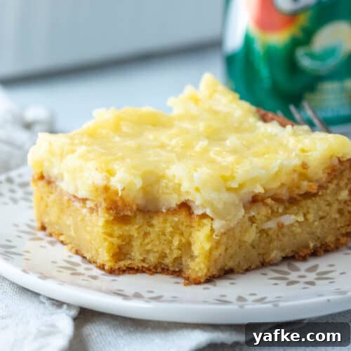 slice of 7up cake topped with a coconut frosting next to a can of 7up.