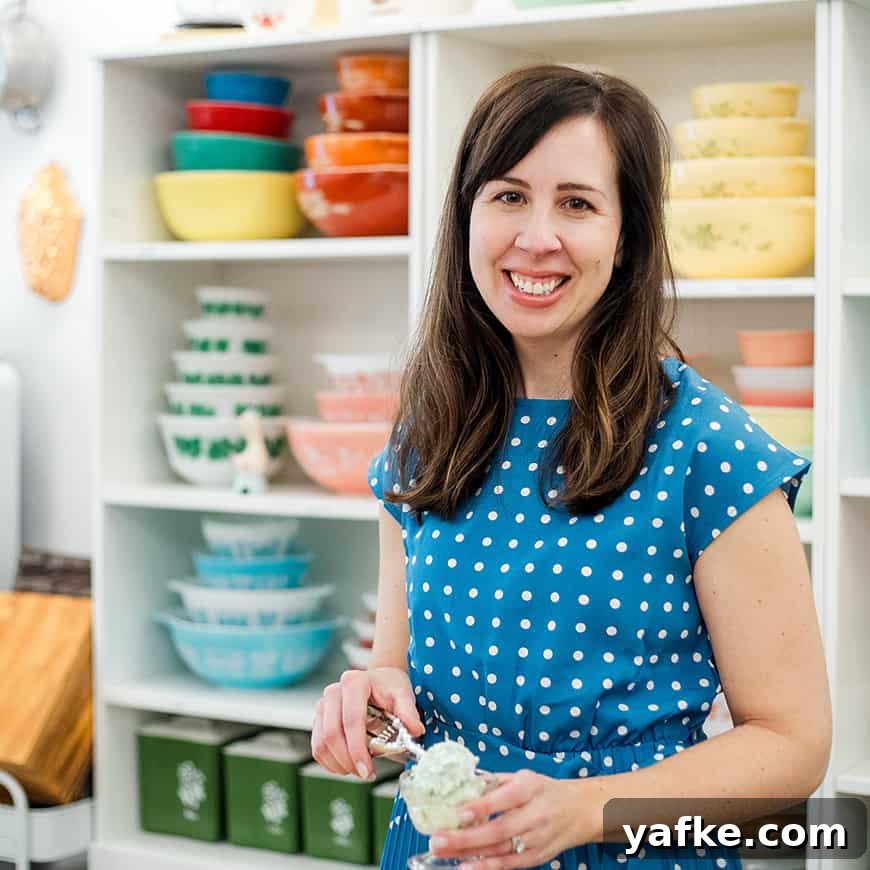 woman scooping pistachio salad into a parfait dish, with colorful vintage bowls in the background.