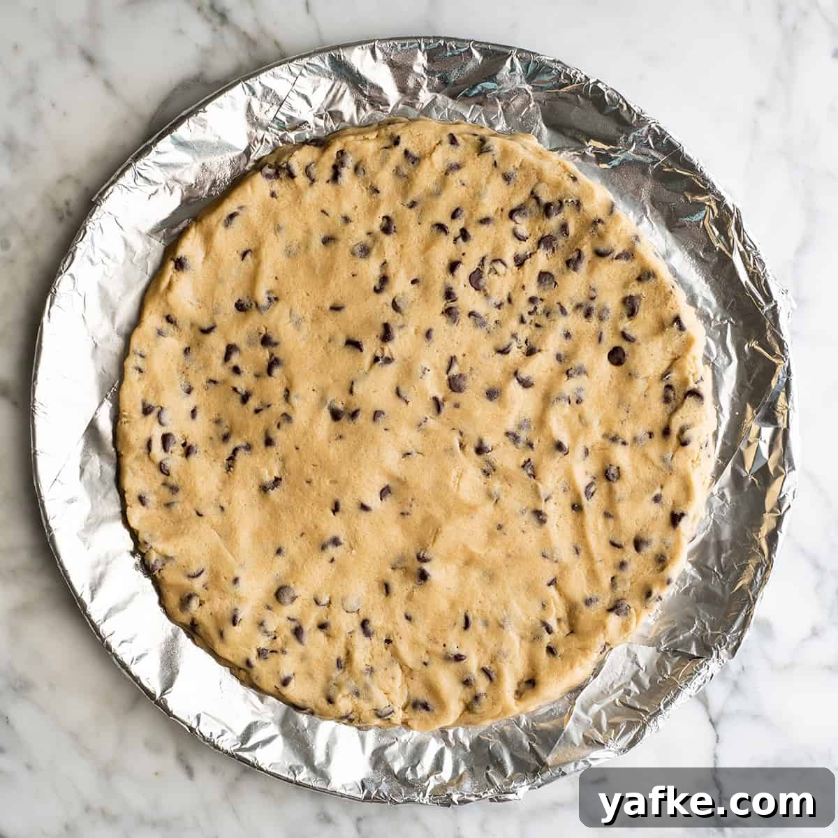 chocolate chip cookie cake on a baking sheet before baking