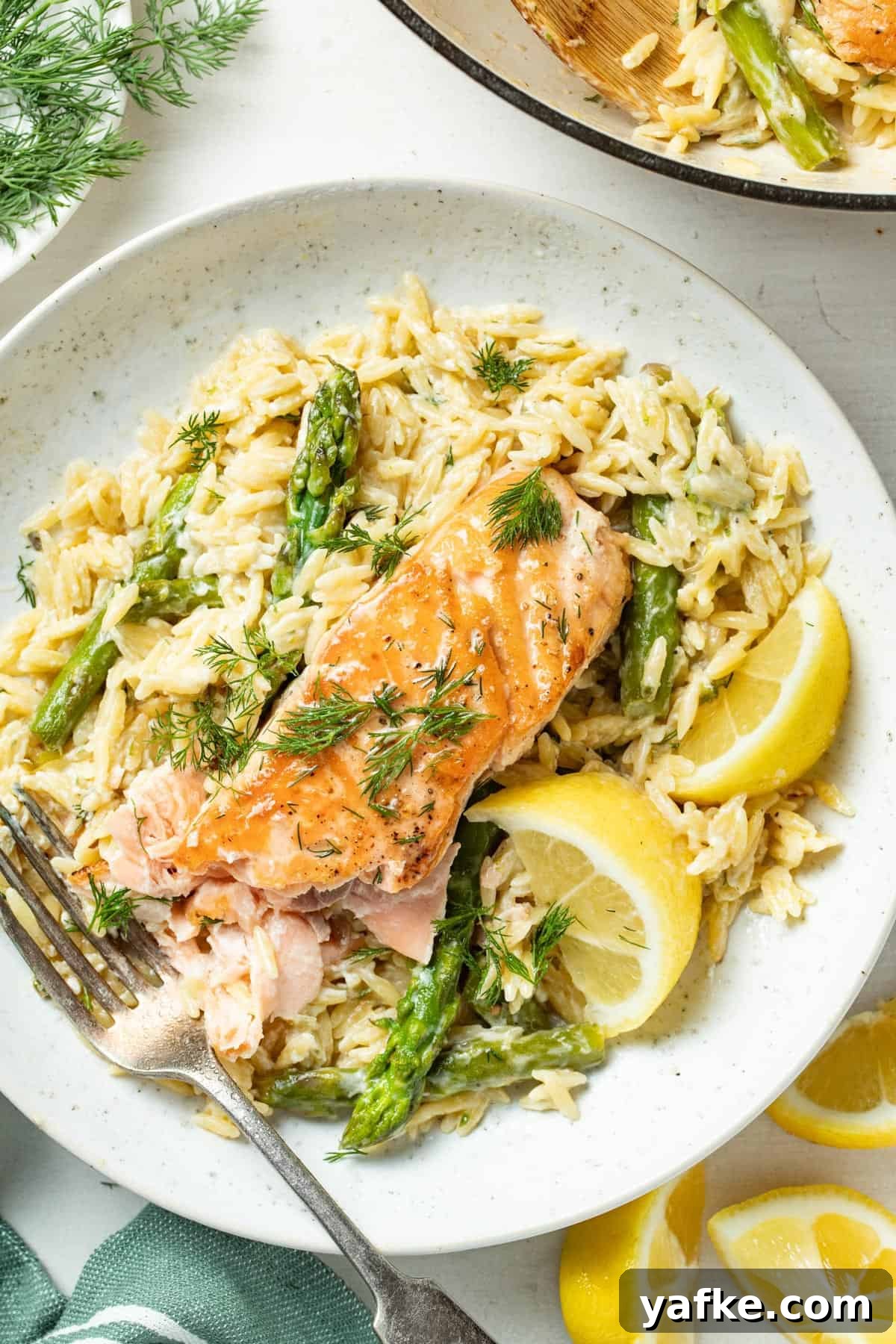 Pan-Seared Salmon with Crispy Skin and Lemon Butter Sauce 4 Seared salmon on top of a plate of orzo with asparagus.