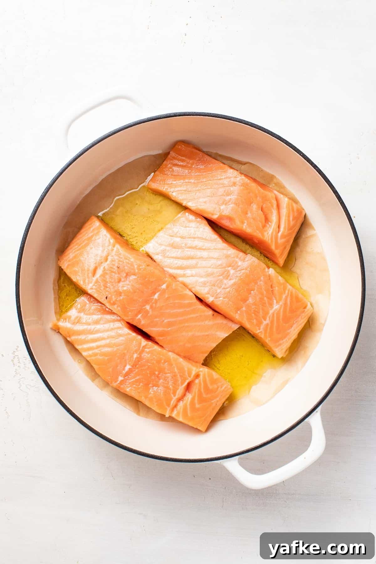 Pan-Seared Salmon with Crispy Skin and Lemon Butter Sauce 6 Salmon fillets in a pan with parchment topped with olive oil.