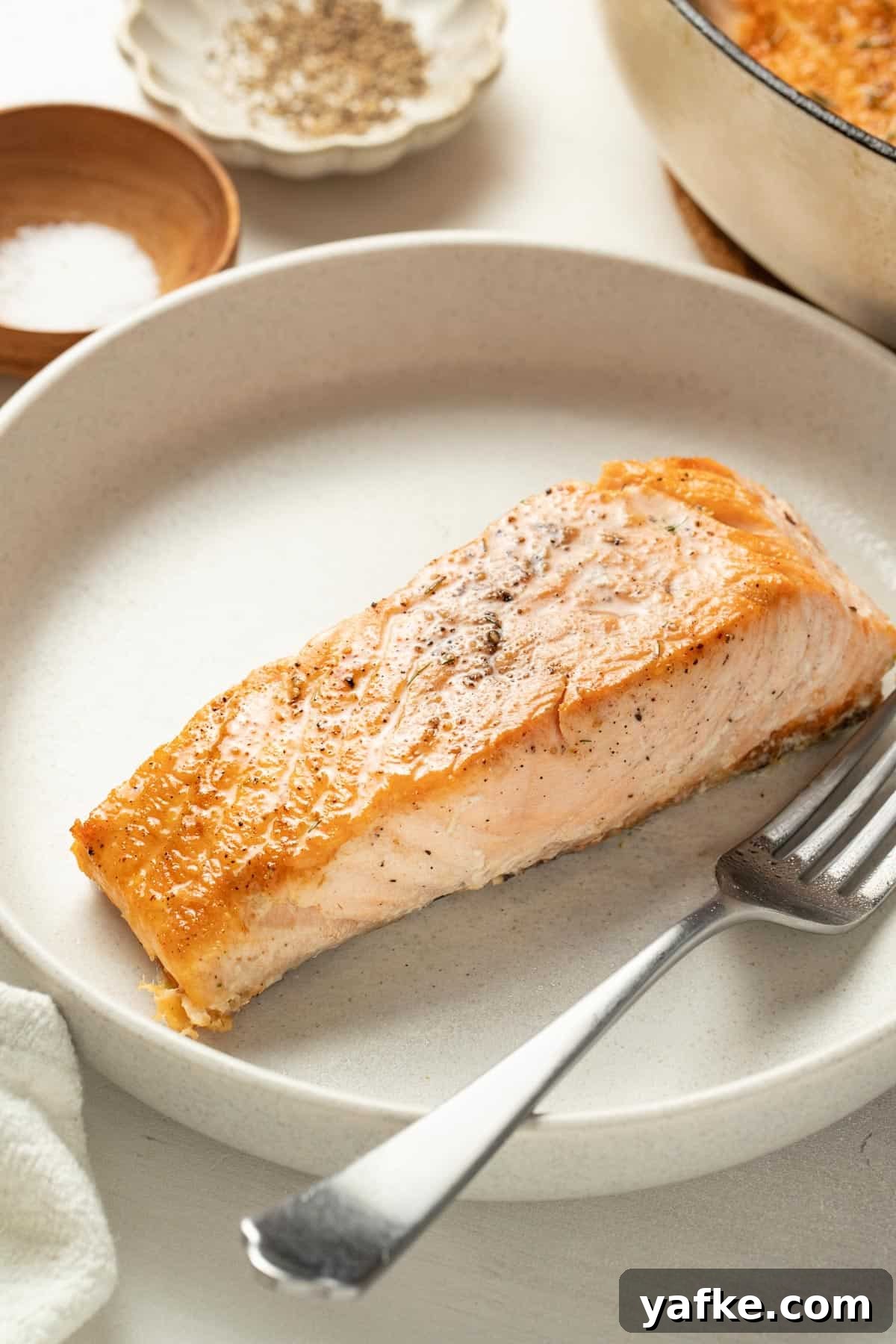 Pan-Seared Salmon with Crispy Skin and Lemon Butter Sauce 8 A crispy, golden brown seared salmon on top of a plate.
