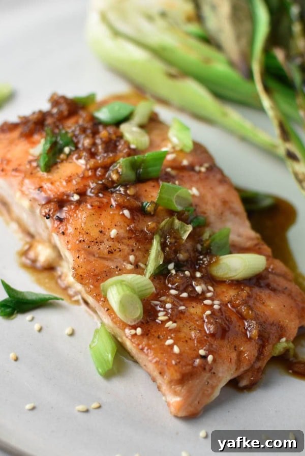 A pan friend teriyaki salmon on a grey plate.
