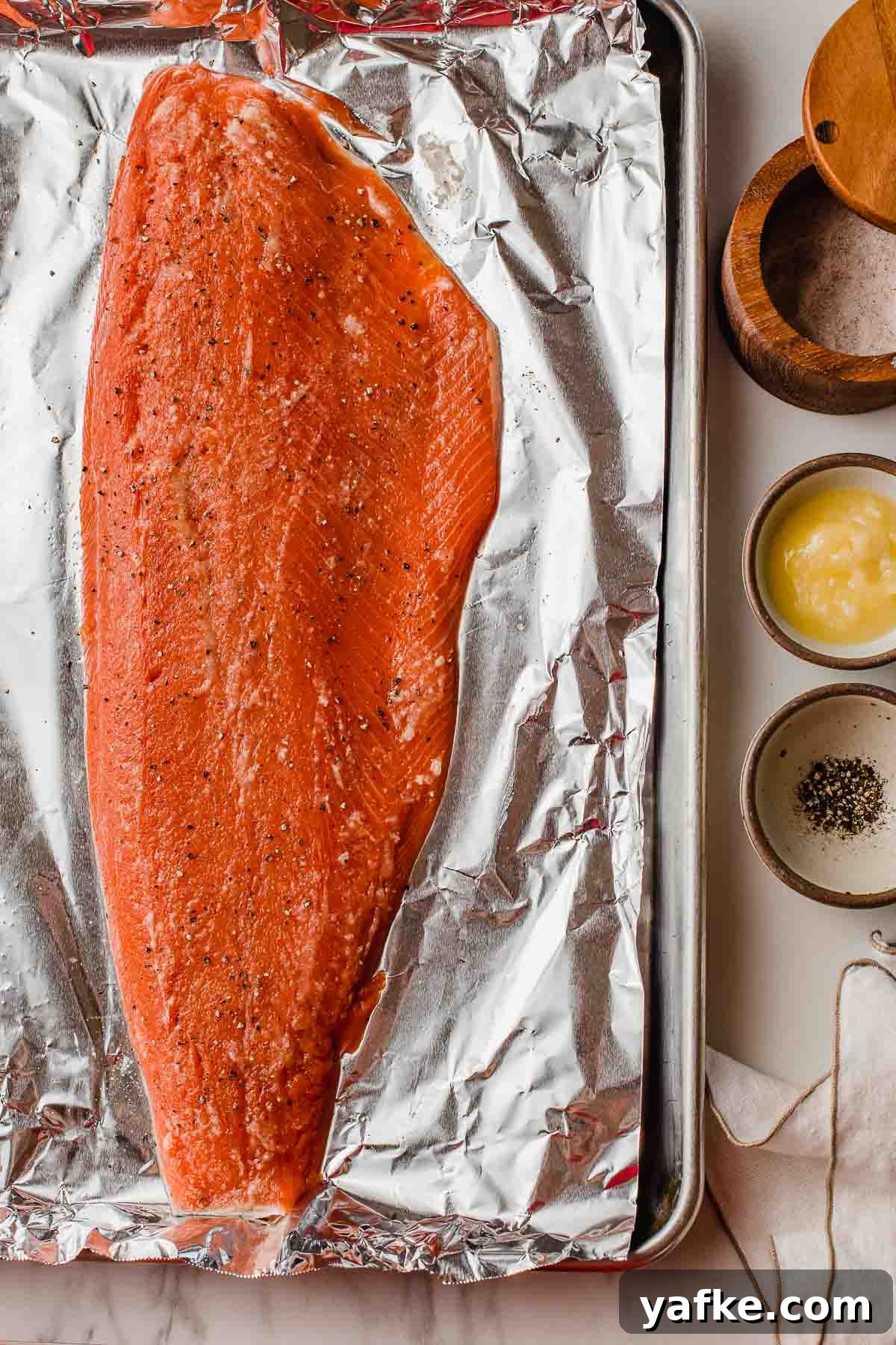 Oven-Baked Salmon with Lemon and Garlic 2 A salmon fillet on a baking sheet.