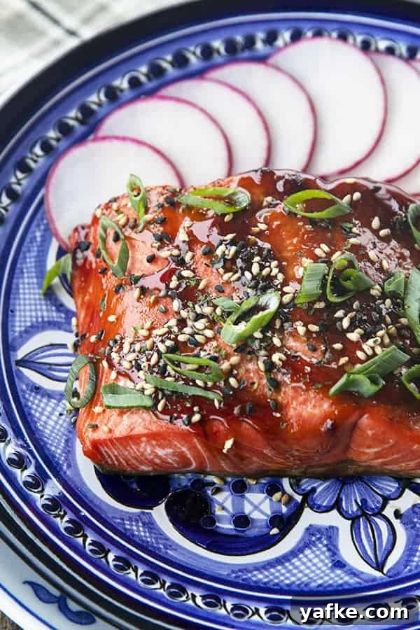 How to Cook Salmon in an Air Fryer 3 Glazed Salmon with sesame seeds and green onions, radishes, on a blue and white plate