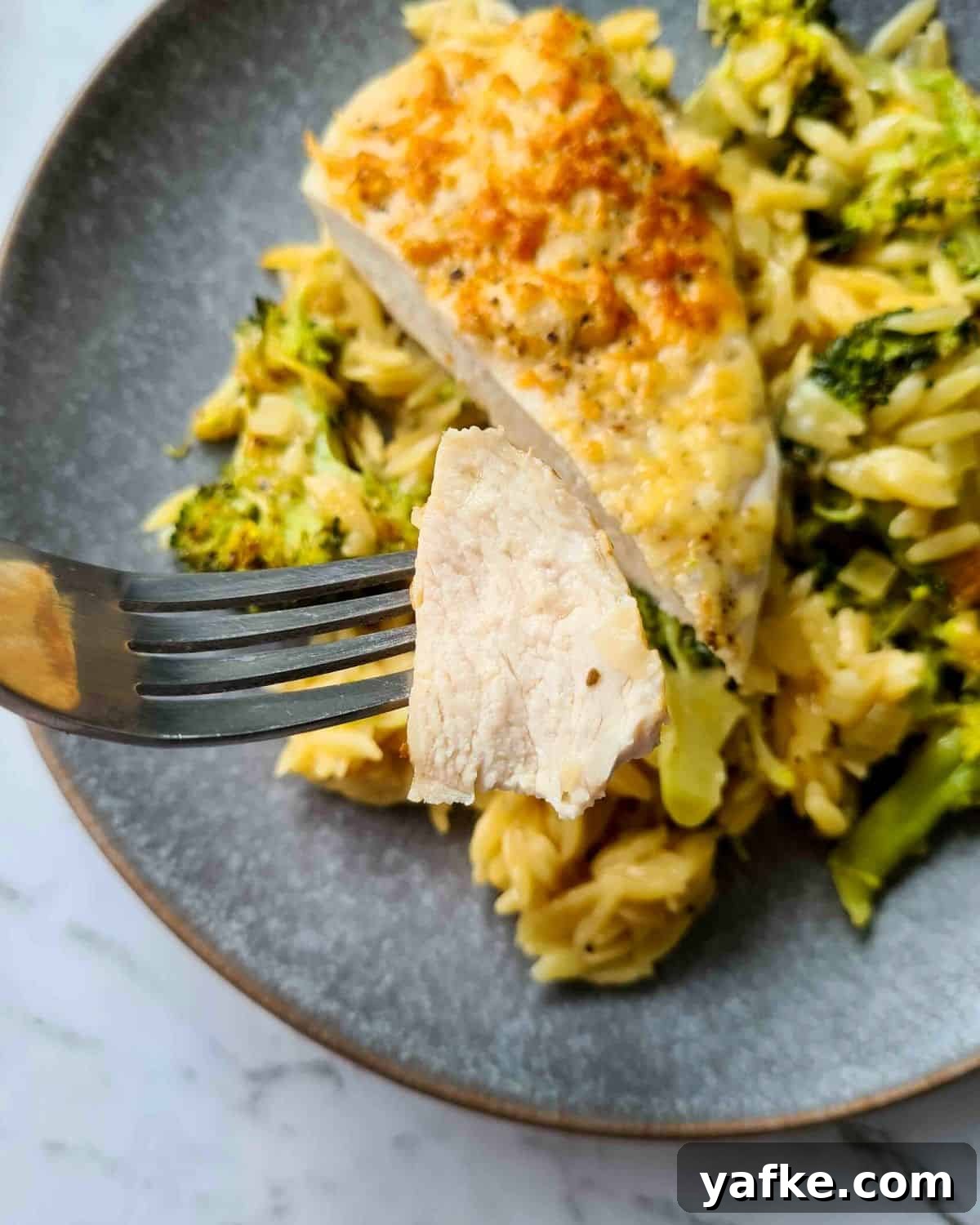 Close up of juicy piece of chicken breast on a fork