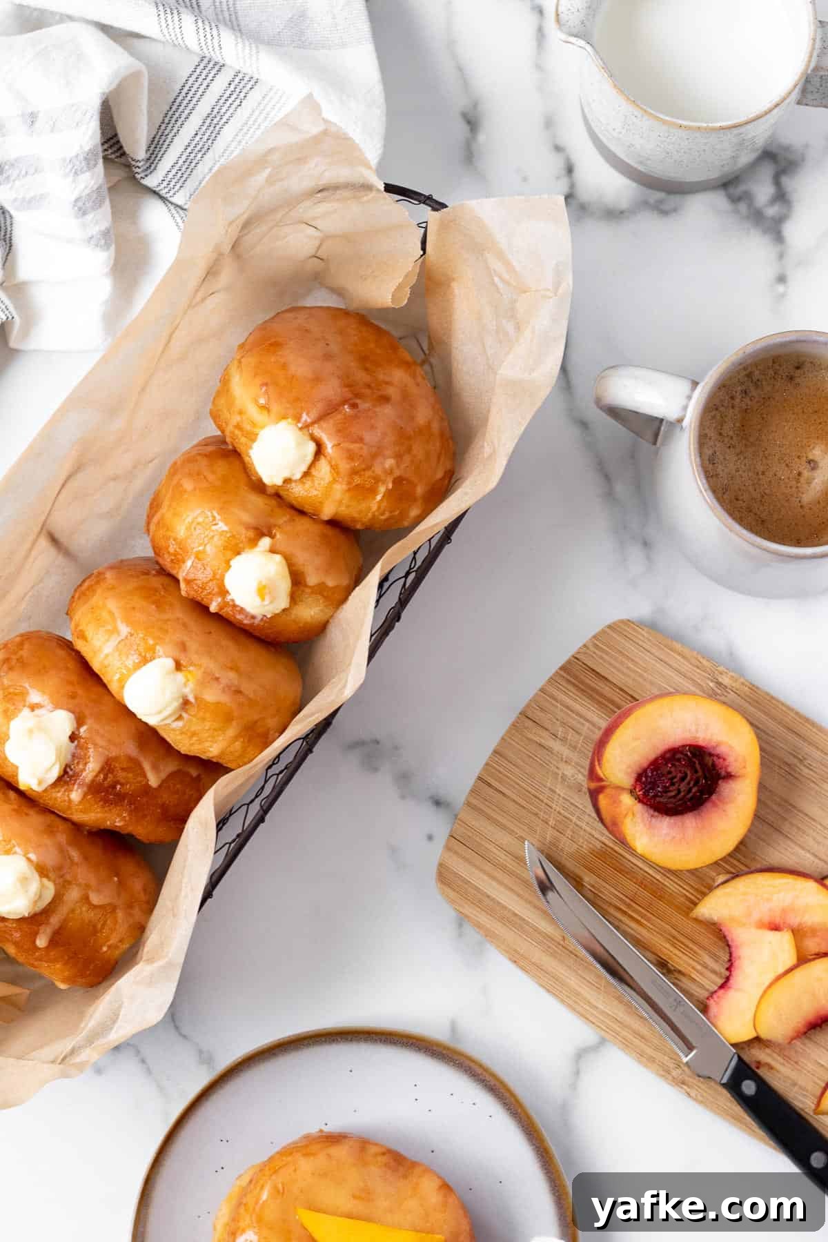 Peach Donuts with Peaches and Cream Filling 2 peach doughnuts with vanilla filling in a basket with cutting board with sliced peach