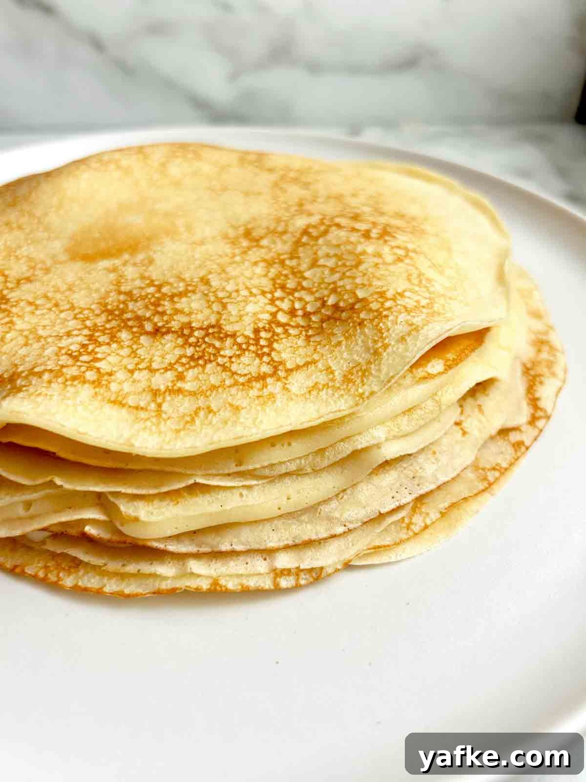 Authentic Swedish Pancake Recipe: Thin Crepe-Style Pancakes 7 stack of Swedish pancakes on plate.