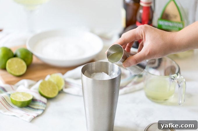 Classic Margarita Cocktail: Recipe, Tips and Variations 6 adding tequila to a cocktail shaker to make a margarita