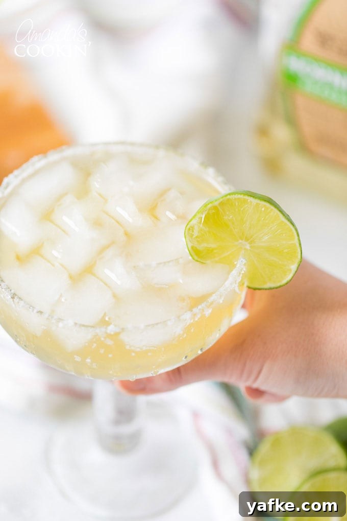 Classic Margarita Cocktail: Recipe, Tips and Variations 7 hand holding a margarita on the rocks