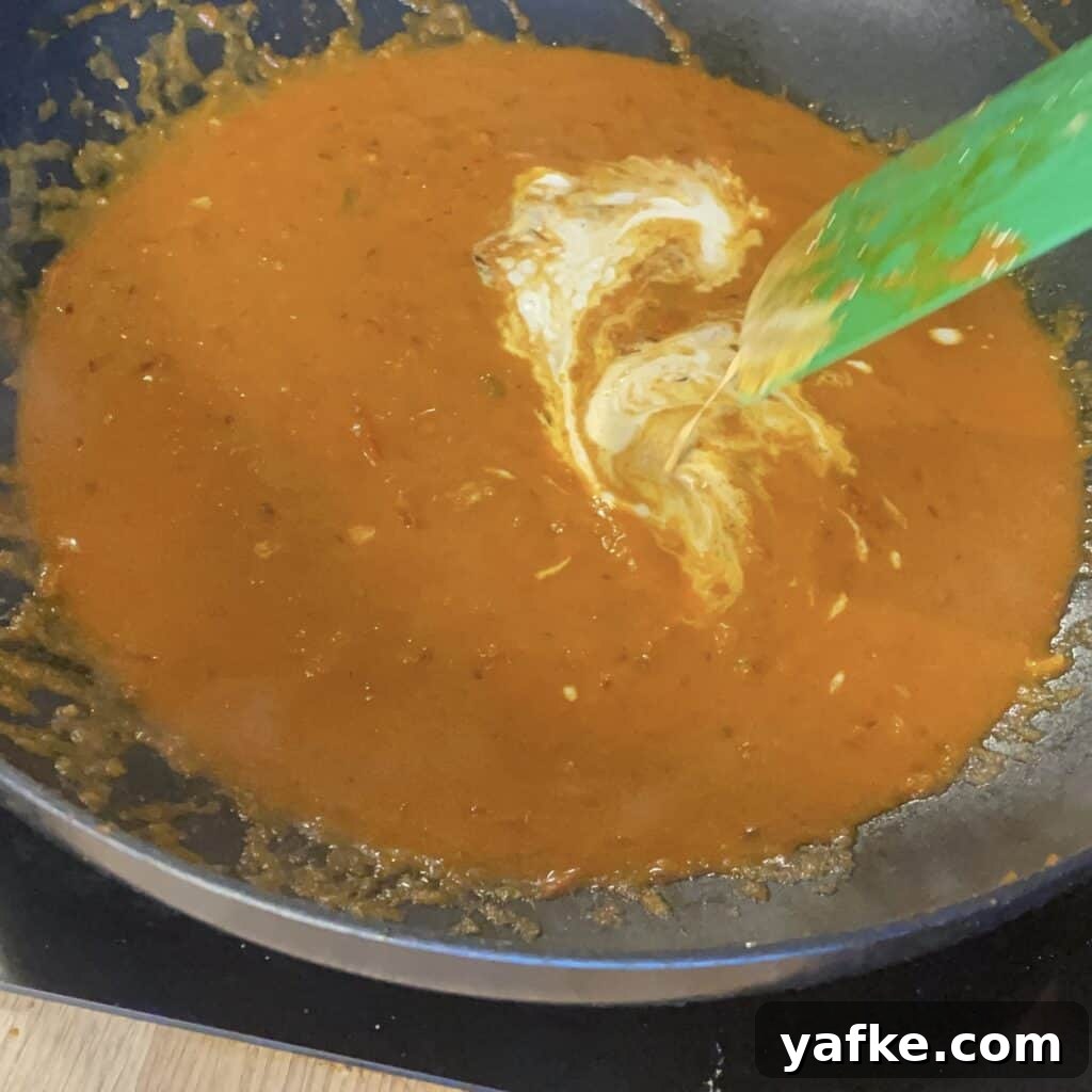 30-Minute Butter Chicken Recipe: Creamy Indian Curry 6 Double cream being added and stirred into the sauce