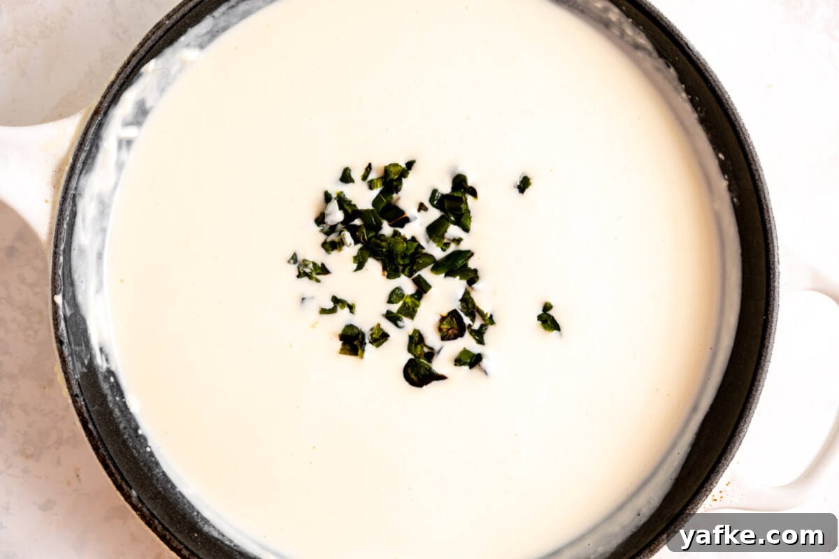 Creamy White Queso Dip Recipe for Tacos and Chips 5 Skillet with white queso and roasted jalapeno added.