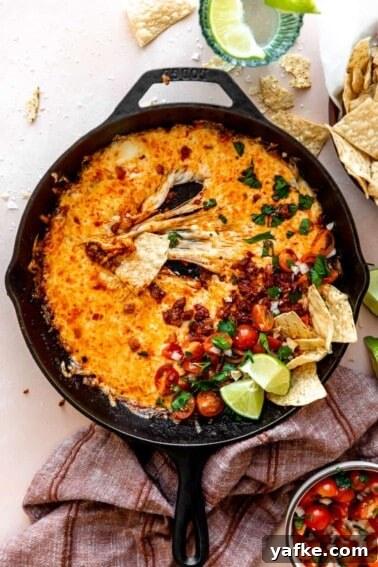 Creamy White Queso Dip Recipe for Tacos and Chips 7 stretchy melted cheese in a skillet with chorizo and pico de Gallo.