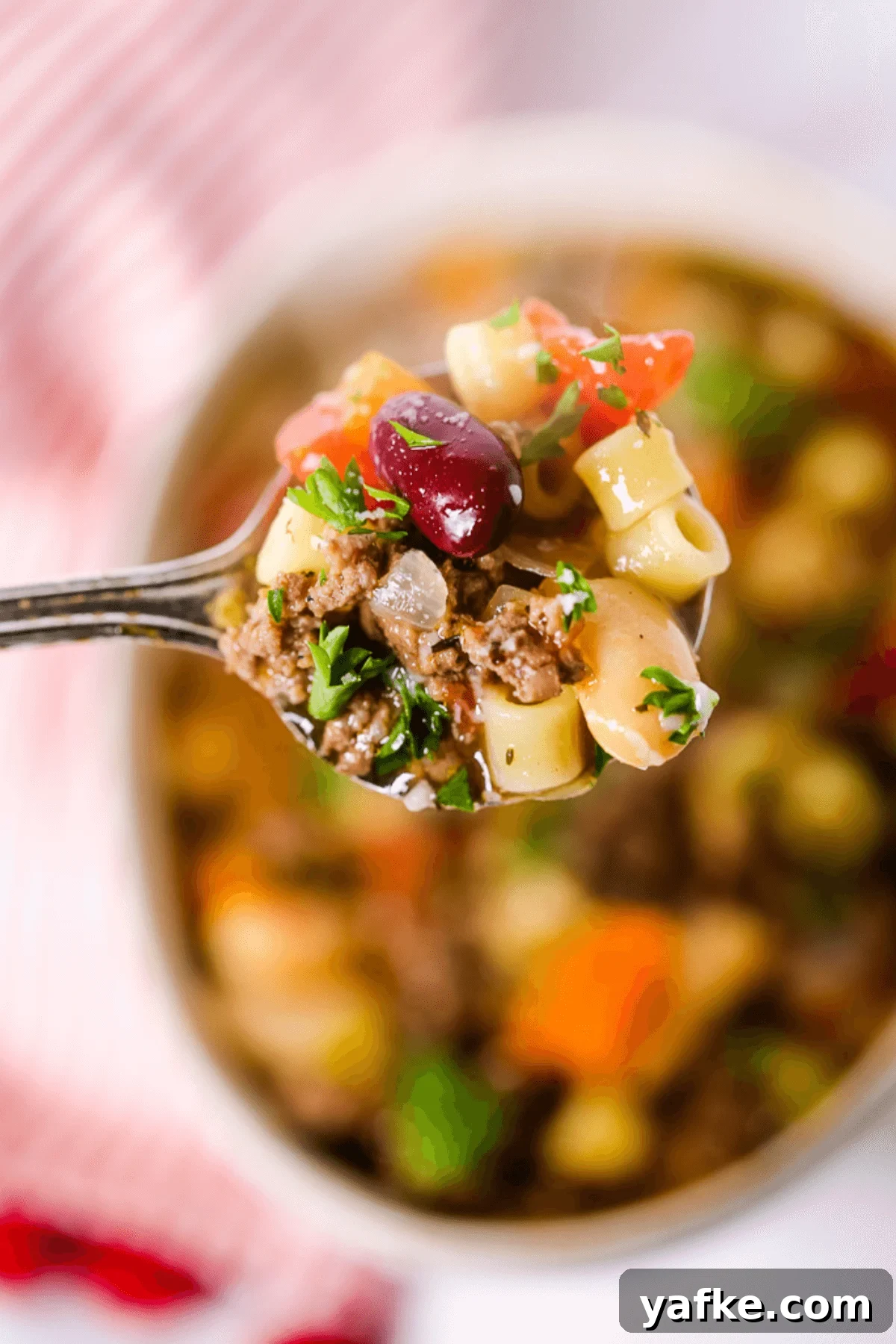 Olive Garden Pasta Fagioli Soup Copycat Recipe (Pasta Fazool) 2 A spoonful of the Italian dish on a stripped placemat.