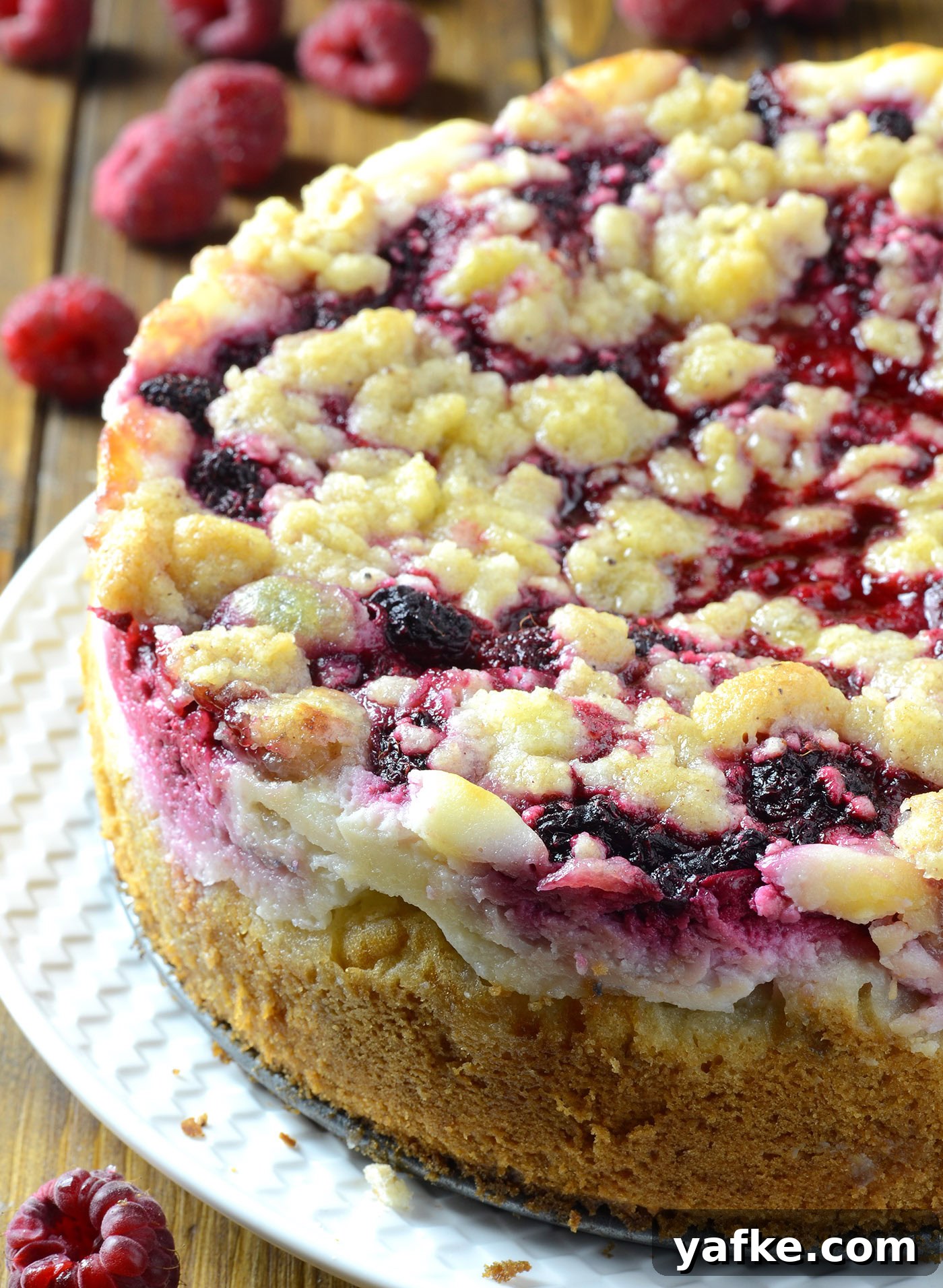 whole raspberry cream cheese coffee cake with streusel topping and layers of raspberry and cream cheese