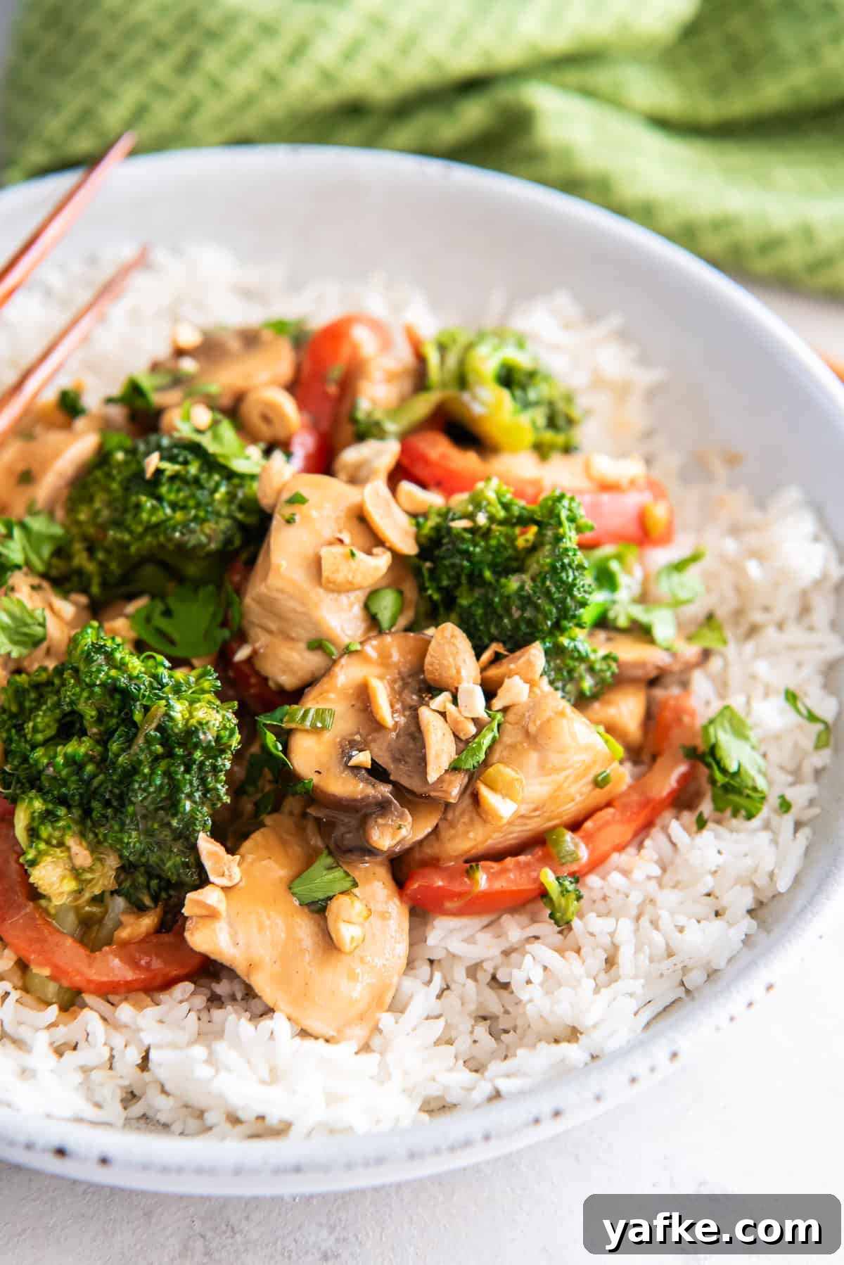 Peanut Chicken Stir-Fry Recipe with Vegetables 7 A bowl of rice topped with peanut chicken stir fry.