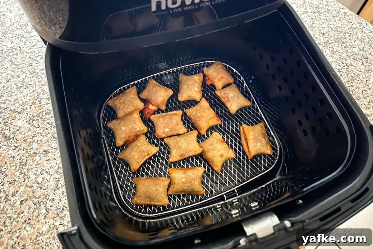 Crispy Homemade Air Fryer Pizza Rolls 5 Cooked rolls in the air fryer basket
