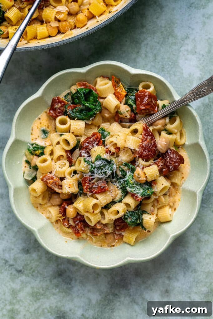 Marry Me Chickpeas One-Pot Pasta Recipe 2 Bowl serving of pasta dish with chickpeas, sun-dried tomatoes in a creamy sauce with Parmesan and spinach