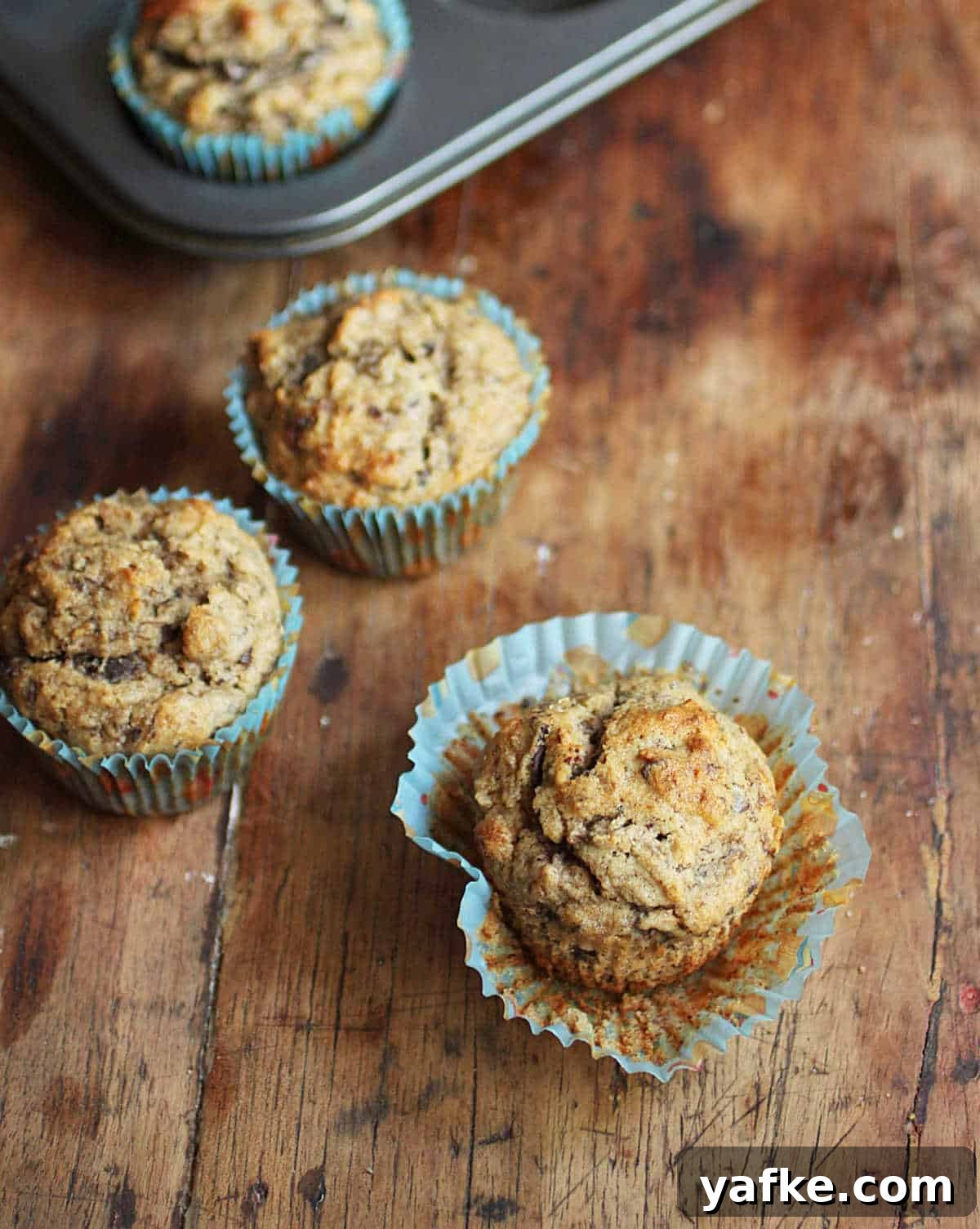 Gluten-Free Banana Chocolate Chip Muffins Recipe 3 Top view of banana muffins on a wooden table.
