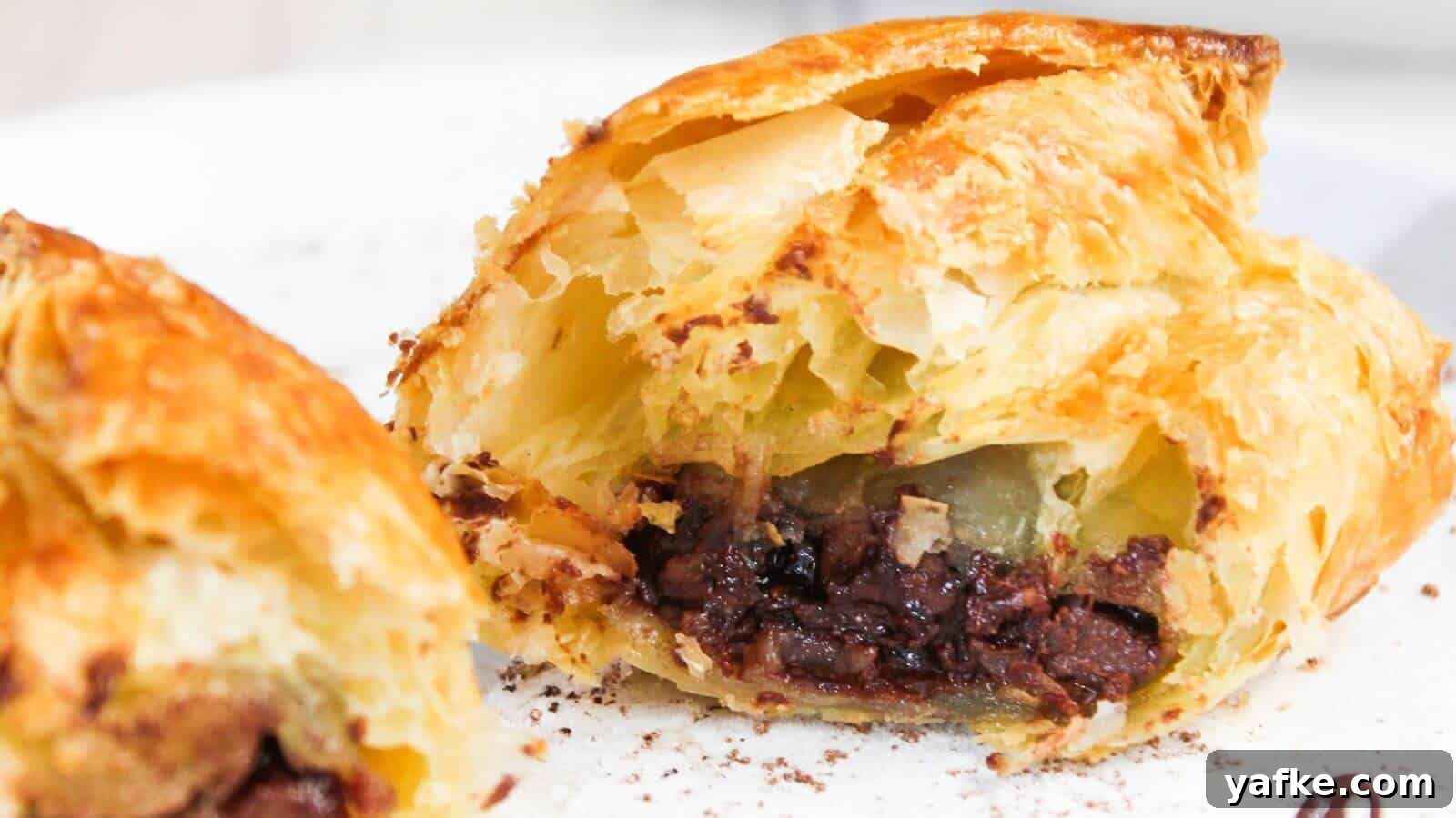11 Air Fryer Dessert Recipes That Will Make You Ditch the Oven 10 Close-up of a flaky pastry cut open to reveal a filling of chocolate, with a visible crispy golden crust.