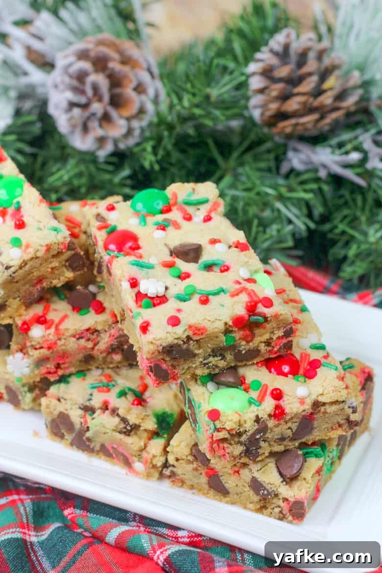Chewy Christmas Cookie Bars Recipe with Festive Sprinkles 2 Christmas Cookie Bars with chocolate chips, sprinkles, and red and green M&Ms.