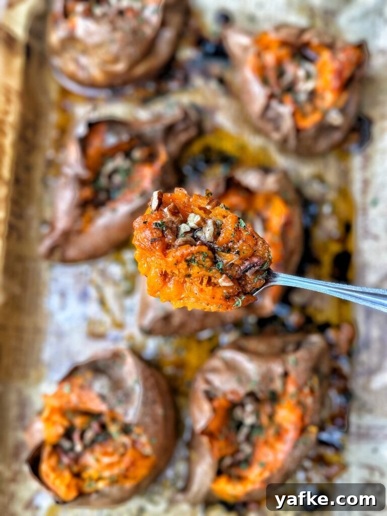 Baked Sweet Potatoes with Savory Maple Butter Recipe 10 A spoon of baked sweet potato topped with savory maple butter, pecans, flaky salt, and chives
