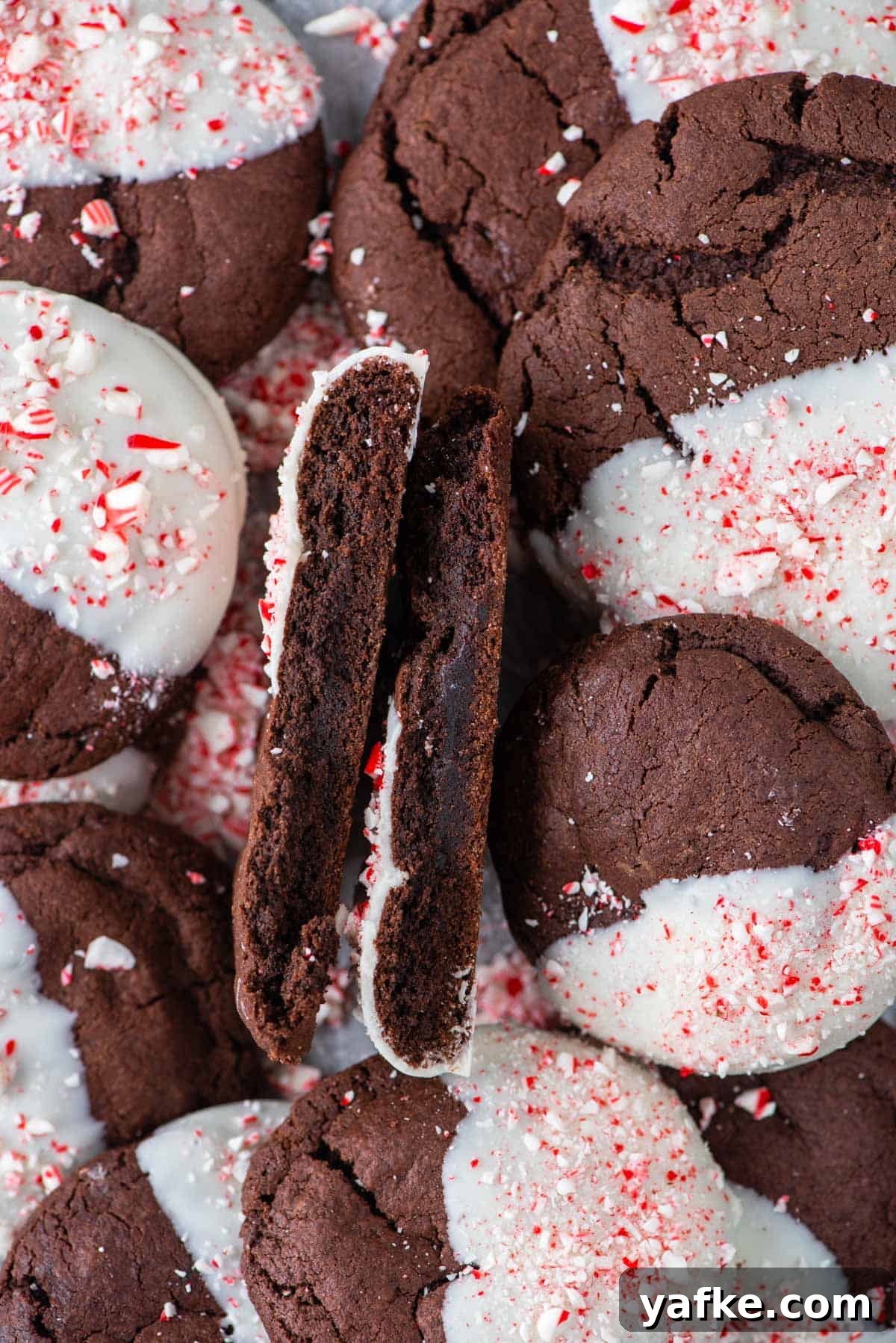 A candy cane chocolate cookie cut in half on top of other cookies